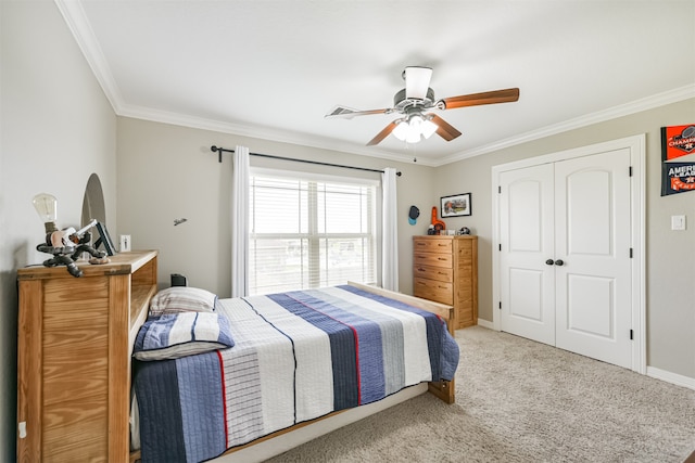 carpeted bedroom with ceiling fan, ornamental molding, and a closet