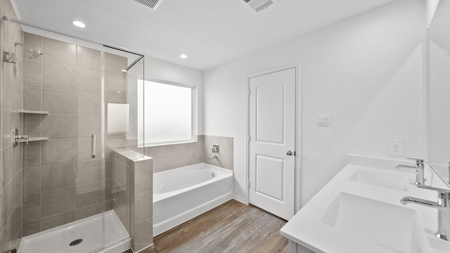 bathroom featuring vanity, plus walk in shower, and wood-type flooring