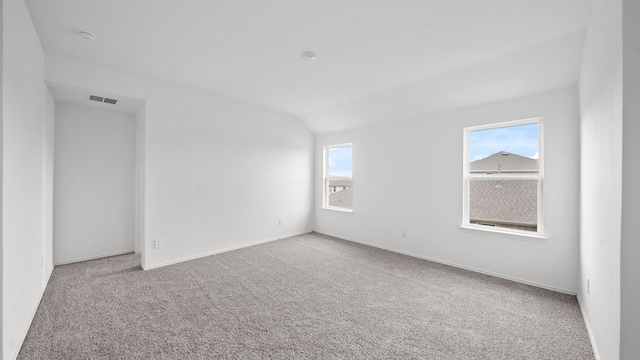 empty room with carpet floors and lofted ceiling