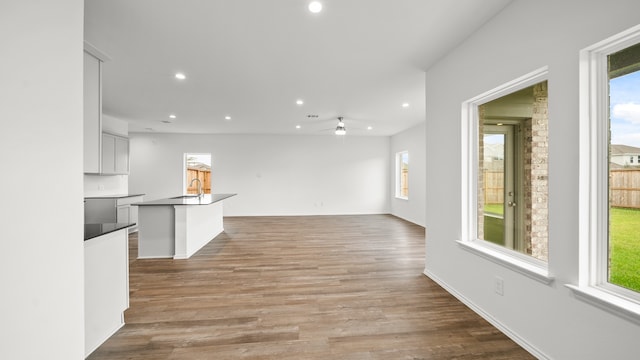 unfurnished living room featuring ceiling fan, light wood-type flooring, and sink