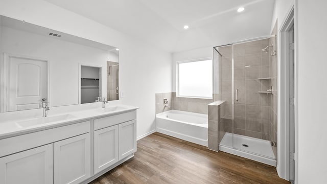 bathroom with wood-type flooring, vanity, and independent shower and bath