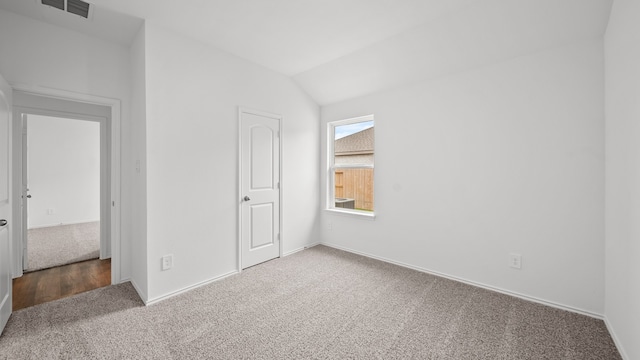 unfurnished bedroom with a closet, carpet floors, and lofted ceiling