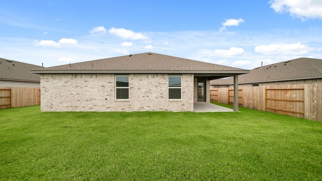 rear view of house featuring a yard and a patio