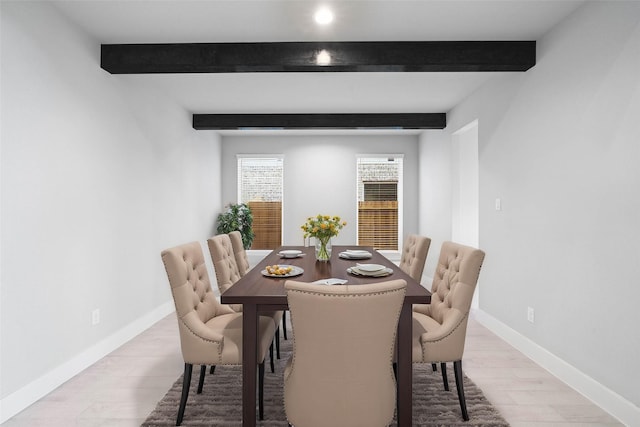 dining space with light hardwood / wood-style flooring and beamed ceiling