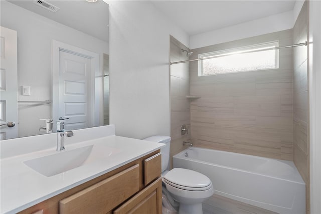 full bathroom with hardwood / wood-style flooring, tiled shower / bath combo, toilet, and vanity