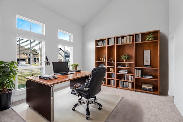 office space featuring high vaulted ceiling, light carpet, and a wealth of natural light