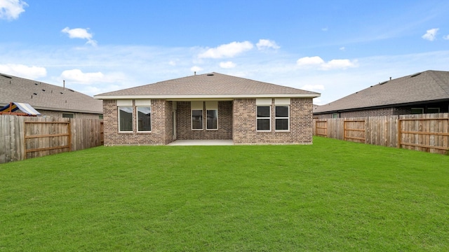 back of house featuring a lawn and a patio