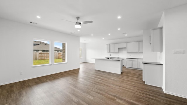 kitchen featuring ceiling fan, dark hardwood / wood-style flooring, sink, and a kitchen island with sink