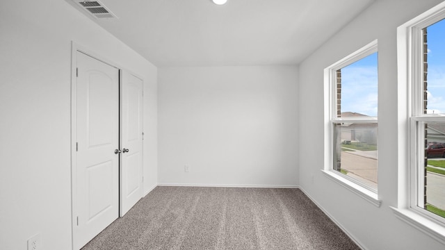 unfurnished bedroom featuring carpet flooring and multiple windows