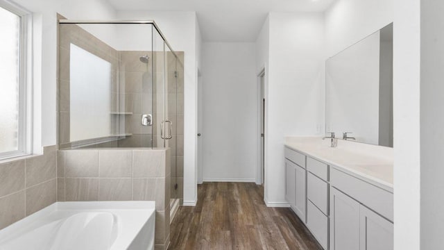 bathroom featuring hardwood / wood-style floors, vanity, and shower with separate bathtub