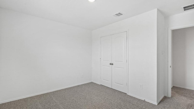 unfurnished bedroom featuring carpet flooring and a closet