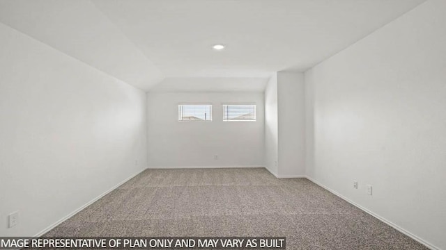 spare room with light colored carpet and vaulted ceiling