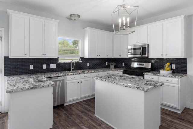 kitchen featuring a center island, white cabinetry, stainless steel appliances, and dark wood-type flooring