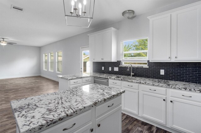 kitchen featuring dark hardwood / wood-style flooring, sink, dishwasher, a center island, and white cabinetry