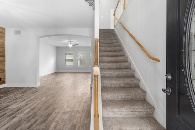 stairway featuring hardwood / wood-style flooring and ceiling fan