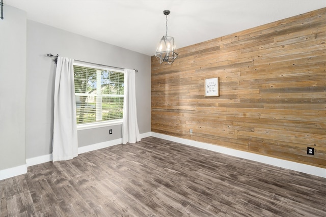 spare room featuring dark hardwood / wood-style flooring and wooden walls