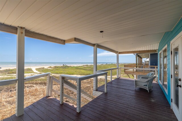 deck with a view of the beach and a water view