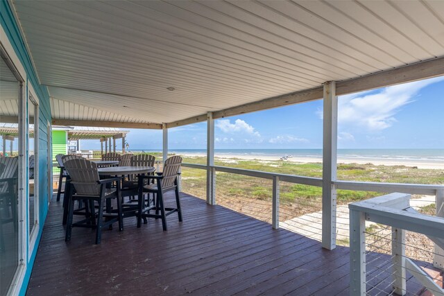 wooden deck with a water view and a view of the beach