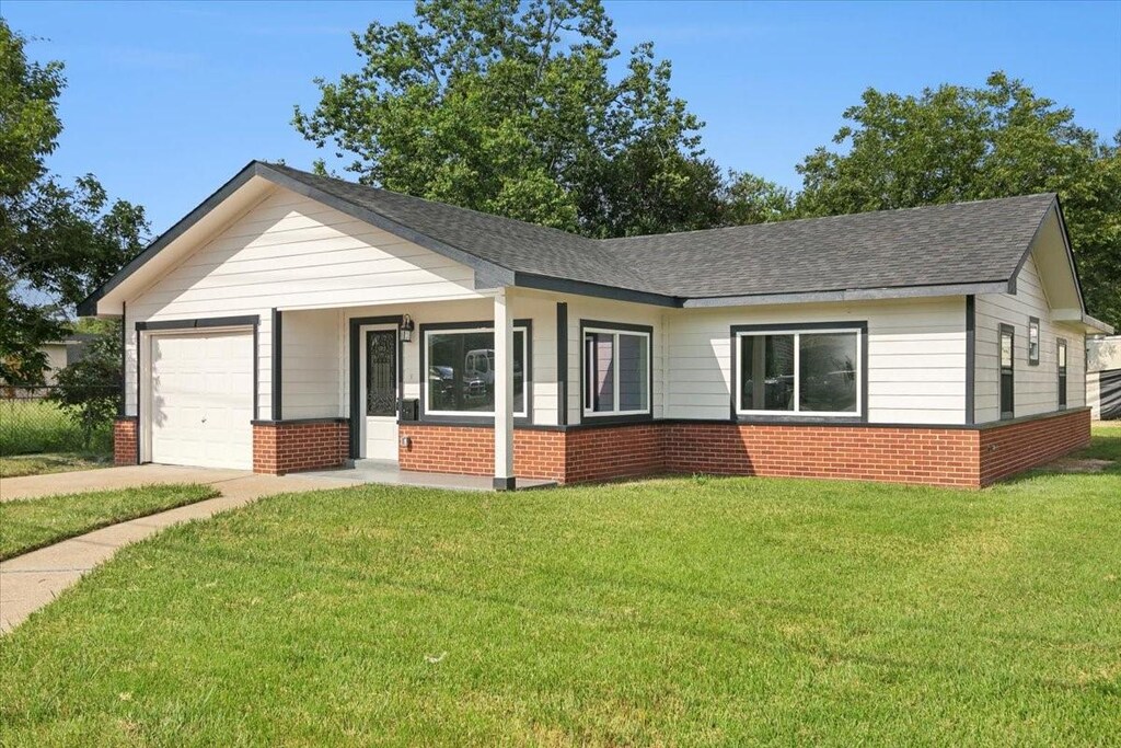 4620 Magnolia St, Beaumont, TX 77703 - ranch-style home featuring a garage, concrete driveway, brick siding, a front lawn, and roof with shingles