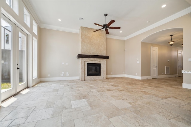 unfurnished living room with ceiling fan, ornamental molding, and a high end fireplace