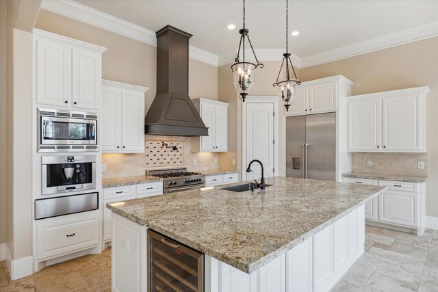 kitchen featuring white cabinetry, sink, beverage cooler, premium range hood, and built in appliances