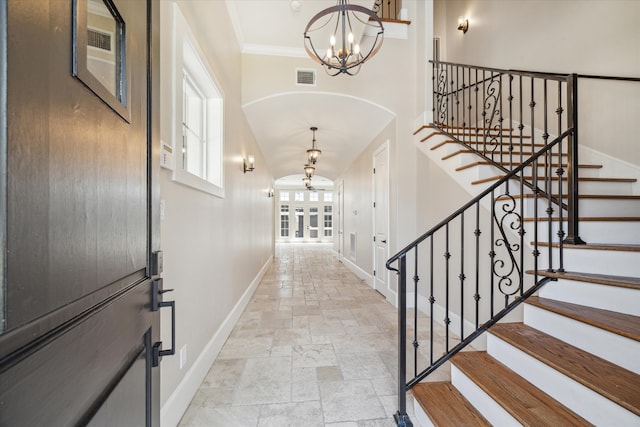 entryway featuring crown molding and a chandelier