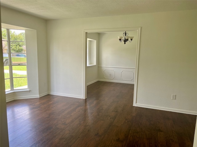 spare room featuring dark hardwood / wood-style floors and a textured ceiling