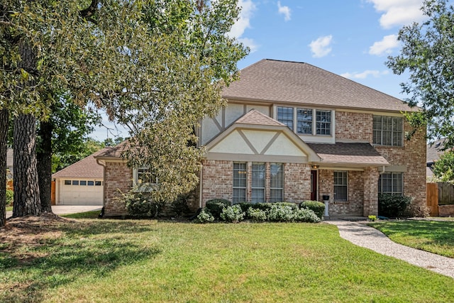 view of front facade with a front yard, a garage, brick siding, and roof with shingles