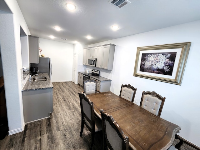 dining space with dark hardwood / wood-style floors and sink