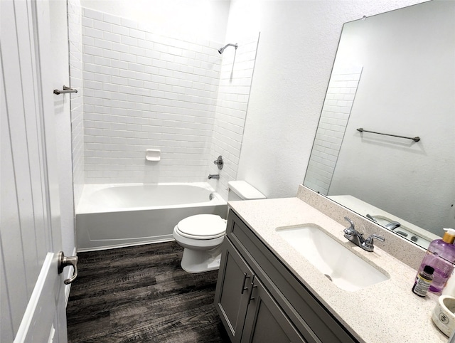 full bathroom featuring toilet, vanity, wood-type flooring, and tiled shower / bath