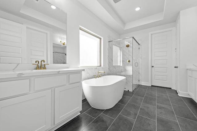 bathroom with tile patterned flooring, vanity, independent shower and bath, and a tray ceiling