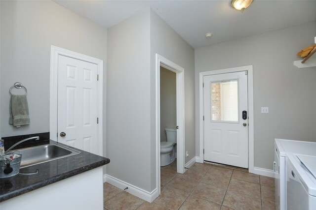 laundry room with light tile patterned floors, sink, and independent washer and dryer