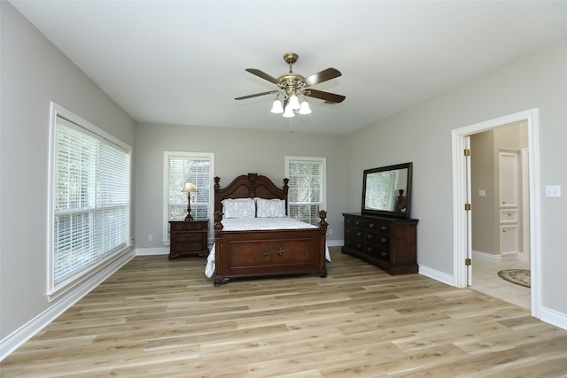 bedroom with ceiling fan, ensuite bath, and light hardwood / wood-style floors