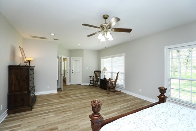 bedroom with ceiling fan, multiple windows, and light hardwood / wood-style floors