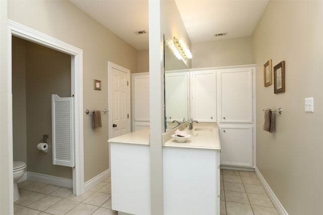 bathroom with vanity, tile patterned flooring, and toilet