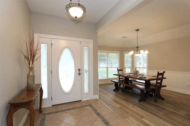 entryway with hardwood / wood-style flooring and a chandelier