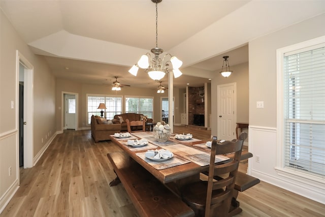 dining space featuring ceiling fan with notable chandelier and wood-type flooring