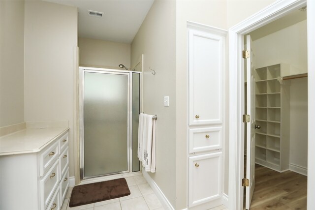 bathroom featuring a shower with shower door, tile patterned floors, and vanity