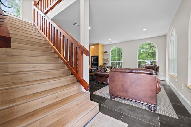 staircase with tile patterned floors and a wealth of natural light