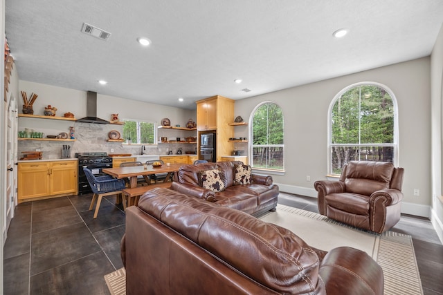 living room featuring dark tile patterned flooring, sink, and a textured ceiling