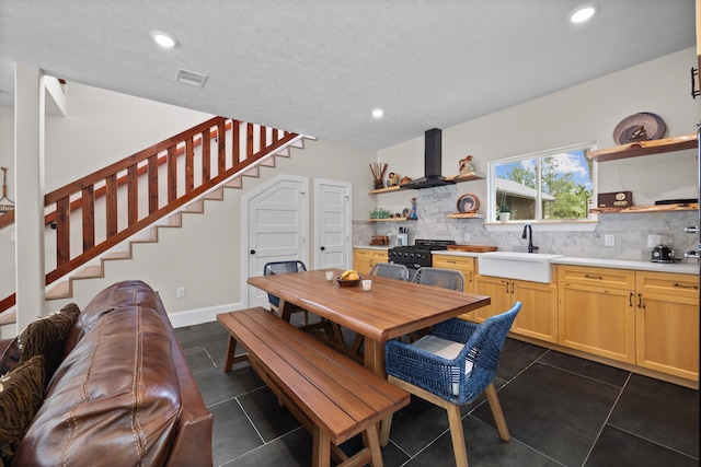 tiled dining area featuring sink and a textured ceiling