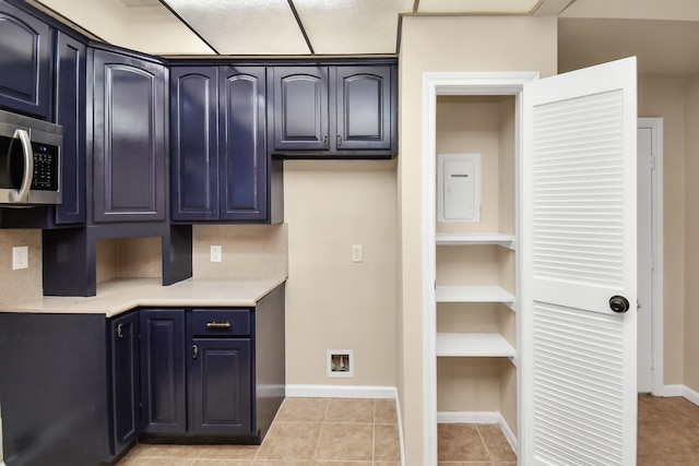 kitchen with electric panel and light tile patterned floors