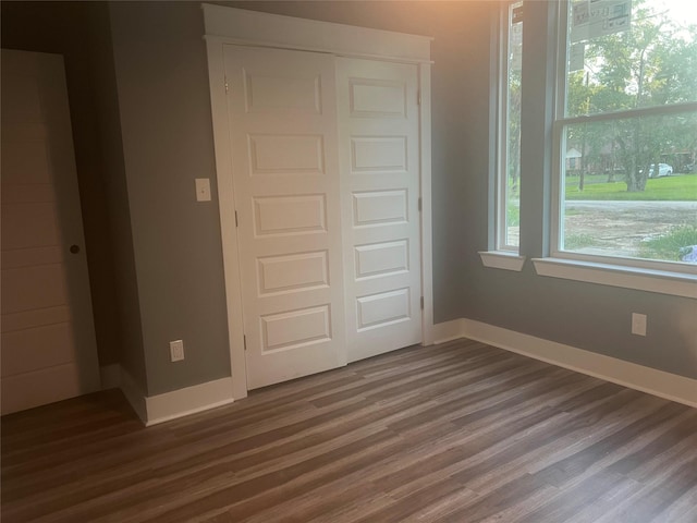 unfurnished bedroom featuring dark hardwood / wood-style floors and a closet