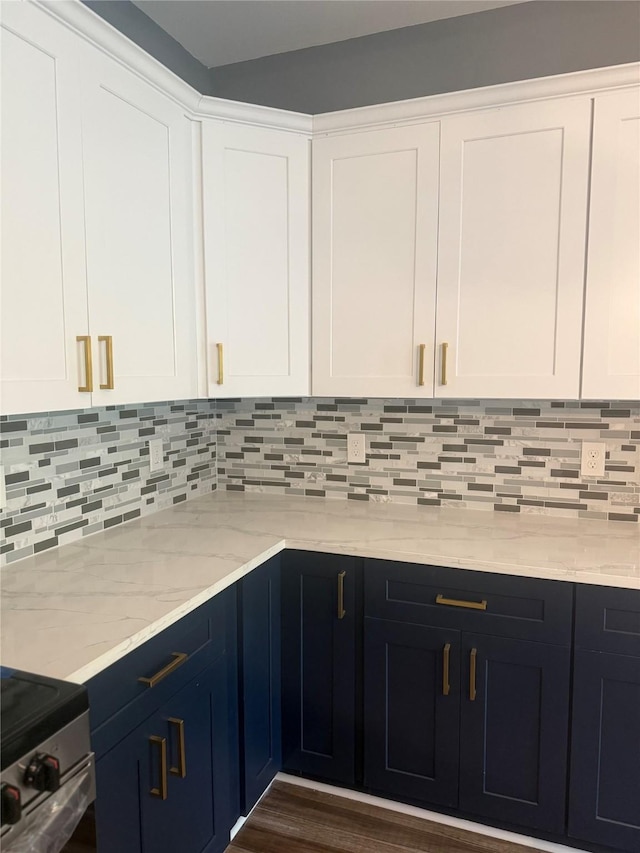 kitchen featuring electric stove, white cabinets, light stone counters, and decorative backsplash