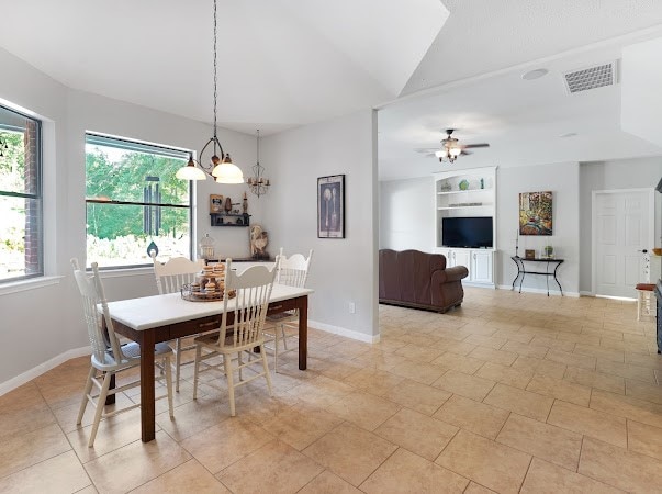 tiled dining space with ceiling fan with notable chandelier, built in features, and lofted ceiling