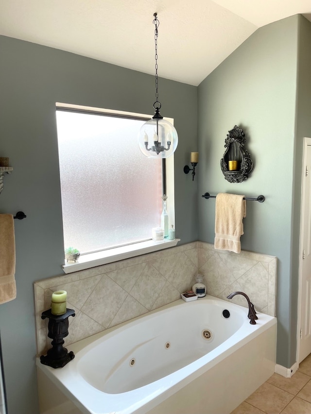 bathroom with tile patterned floors, a bathing tub, and lofted ceiling