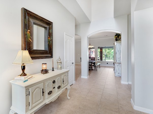 hall featuring light tile patterned flooring and ornamental molding