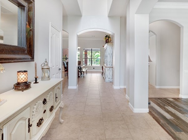 hallway with ornamental molding and light hardwood / wood-style floors