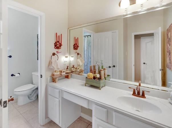 bathroom featuring tile patterned flooring, vanity, and toilet