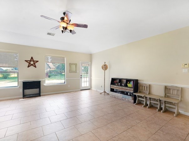 unfurnished living room featuring light tile patterned flooring and ceiling fan